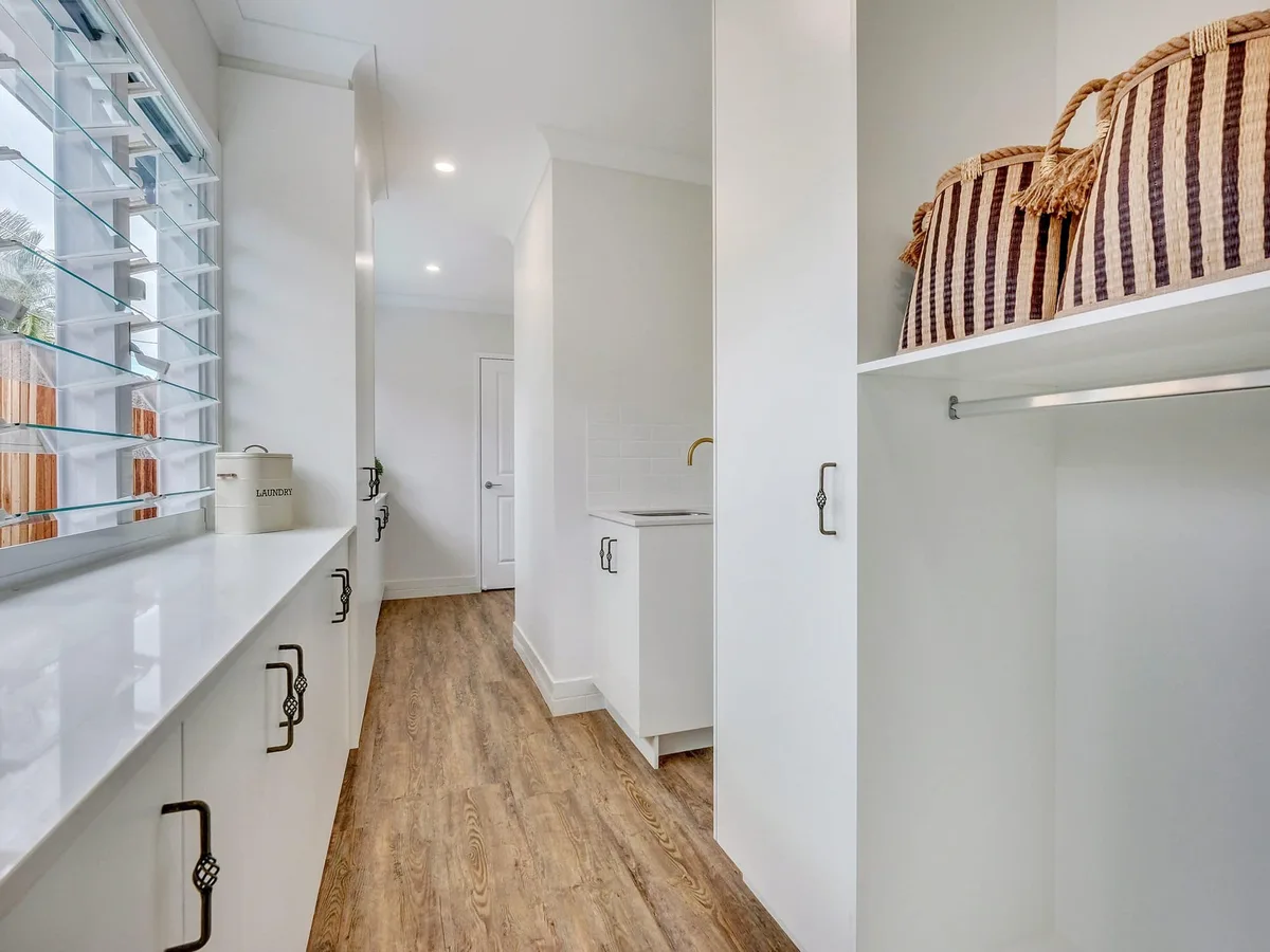 Custom laundry galley with hanging rail, baskets and louvre windows