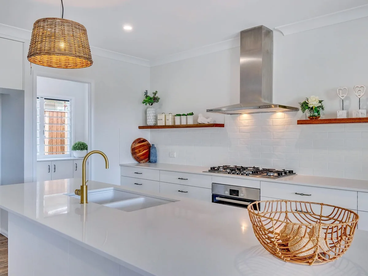 White shaker kitchen with brass tap and timber floating shelf